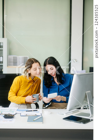 Two businesswoman and man discuss investment project working and planning strategy with tablet 124385525