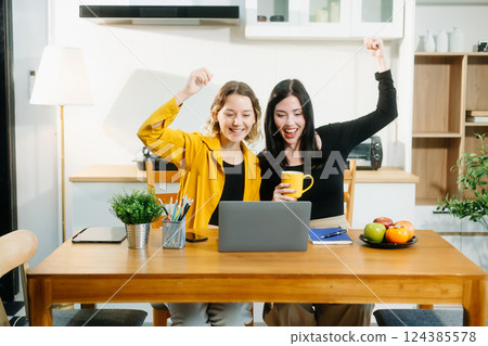 Caucasian Teamwork and creativity with sitting working at kitchen table young collaborating Caucasian Teamwork and creativity with sitting working at kitchen table young collaborating 124385578