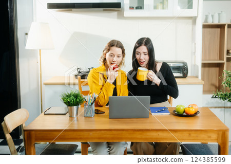Modern couple collaborating over coffee in a cozy kitchen setting with a laptop, notebook, and breakfast. Modern couple collaborating over coffee in a cozy kitchen setting with a laptop, notebook, and breakfast. 124385599