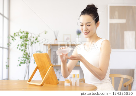 生活方式：一位女士一邊照鏡子一邊進行皮膚護理 124385830