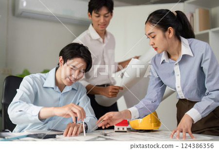 Team Collaboration and Architectural Innovation. Professionals discussing designs and strategies for a construction project. 124386356