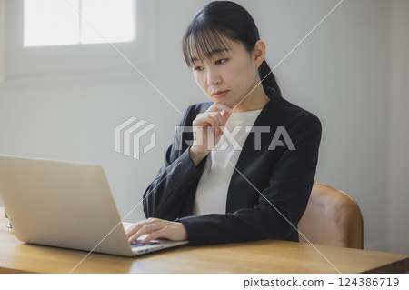 女商人一邊看著電腦螢幕一邊思考 124386719