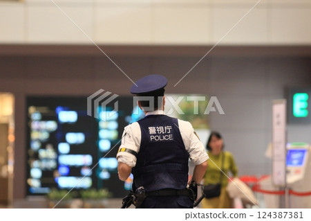 Police officer guarding the airport, rear view, security, police officer of the Metropolitan Police Department 124387381