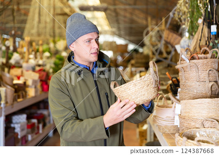 Portrait of man searching wicker basket for storage 124387668