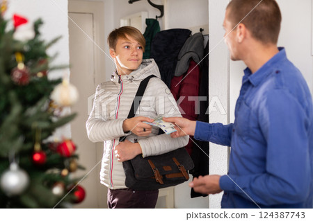 Boy leaving home, his father giving money to him Boy leaving home, his father giving money to him 124387743