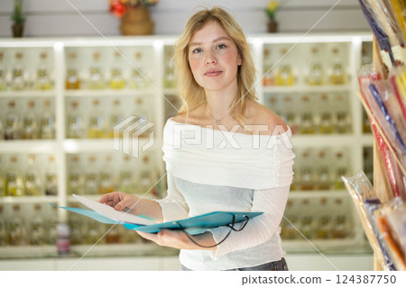 Young woman taking inventory in perfume shop Young woman taking inventory in perfume shop 124387750