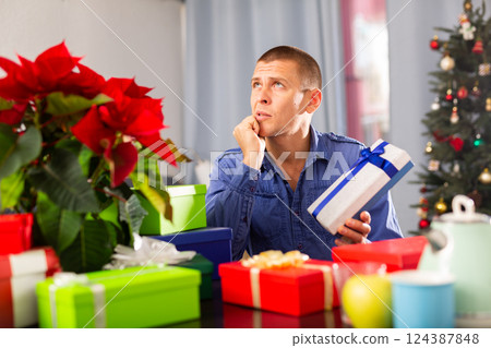 Man sitting at the table with X-mas presents 124387848