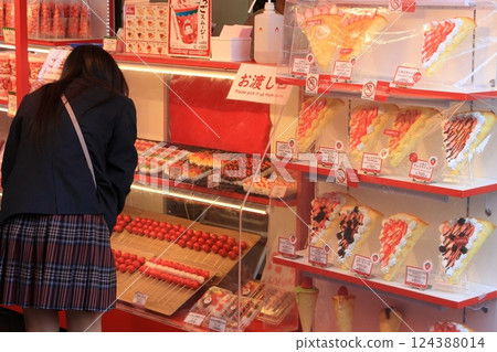 高中女生選擇草莓糖果 — — 旅遊景點的糖果展示 高中女生選擇草莓糖果 — — 旅遊景點的糖果展示 124388014