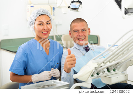 Man is sitting satisfied in chair after treatment in dental clinic 124388062