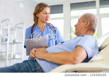 Female nurse carries out questionnaire survey of elderly male patient Female nurse carries out questionnaire survey of elderly male patient 124388105