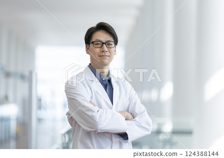 A man in his 40s wearing a white coat smiling at the camera 124388144