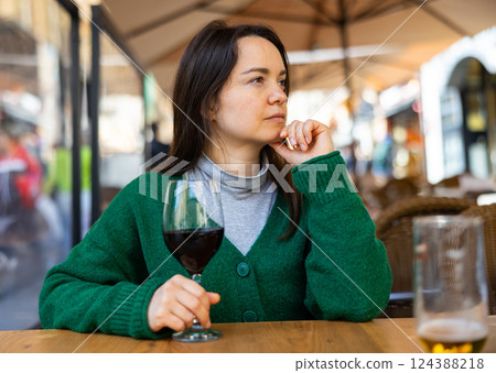 Portrait of thoughtful woman drinking red wine in diner 124388218