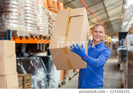 Positive warehouse worker carrying pasteboard box 124388291