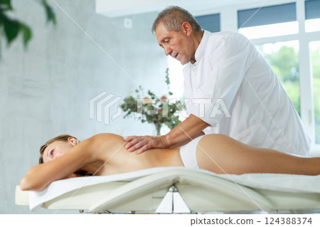 male masseur giving massage to female patient male masseur giving massage to female patient 124388374