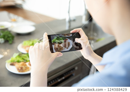 A woman's hands photographing food 124388429