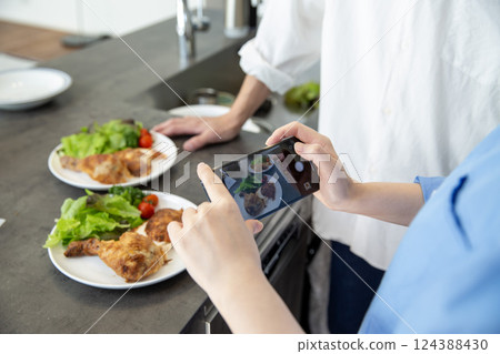 A woman's hands photographing food 124388430
