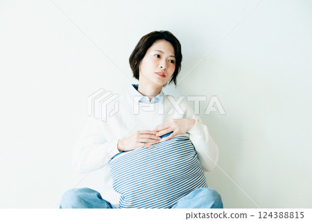 Portrait of a woman sitting by a wall 124388815