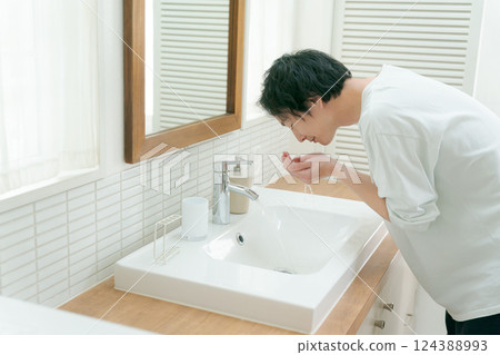 Man washing his face in the bathroom Man washing his face in the bathroom 124388993