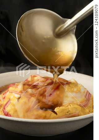 天津飯：用湯匙將熱氣騰騰的醬汁淋在米飯上 124389079