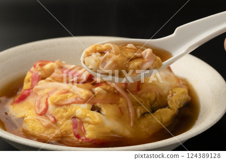 用湯匙舀起熱氣騰騰的天津飯 用湯匙舀起熱氣騰騰的天津飯 124389128