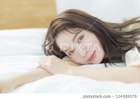 A woman lying on the bed A woman lying on the bed 124389379