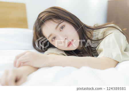 A woman lying on the bed A woman lying on the bed 124389381