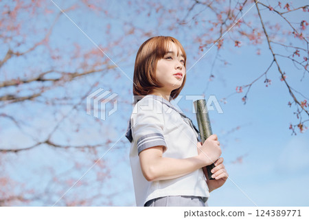 High school girl under the blue sky and cherry blossoms 124389771