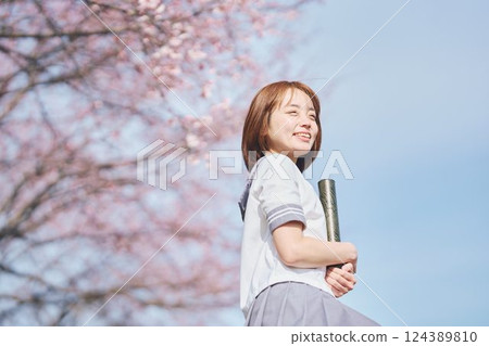 High school girl under the blue sky and cherry blossoms 124389810