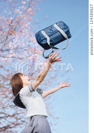 在藍天和櫻花下丟著書包的高中女生 124389827