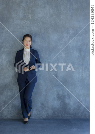 A woman in a suit standing A woman in a suit standing 124389845