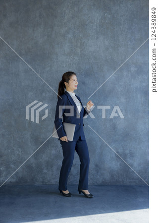A woman in a suit standing A woman in a suit standing 124389849