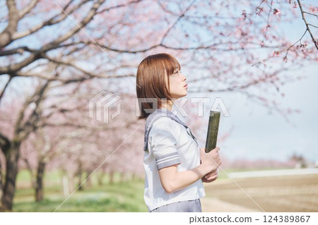 A high school girl with a graduating student under the blue sky and cherry blossoms 124389867