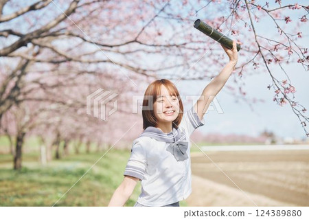 A high school girl with a graduating student under the blue sky and cherry blossoms 124389880