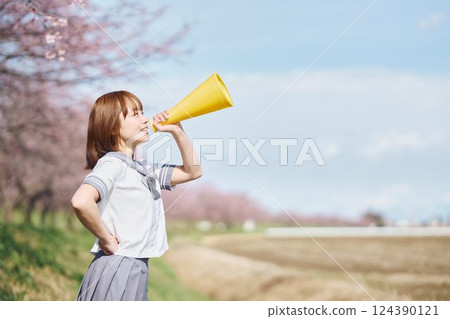 High school girls cheering with megaphones under the cherry blossoms High school girls cheering with megaphones under the cherry blossoms 124390121
