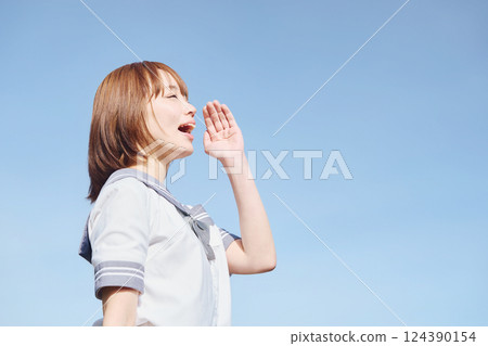 A high school girl calling out under the blue sky 124390154