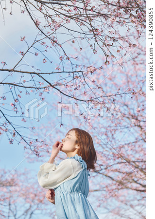 抬頭看著櫻花的年輕女子 124390855