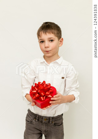 A boy with a gift. A boy on a white background. A child with a gift in his hands A boy with a gift. A boy on a white background. A child with a gift in his hands 124391838
