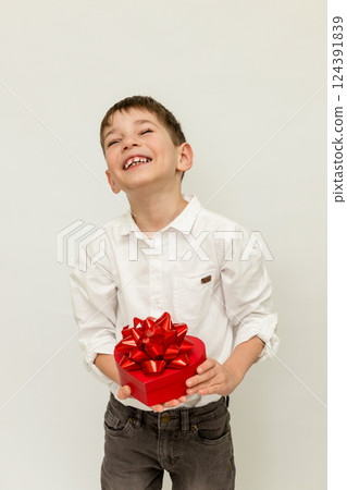 A boy with a gift. A boy on a white background. A child with a gift in his hands 124391839