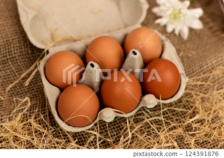 Organic brown eggs in an egg carton. Eggs in a box on straw. Broken Egg Organic brown eggs in an egg carton. Eggs in a box on straw. Broken Egg 124391876