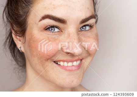 Smiling caucasian woman's face with freckles or age spots, Woman likes her skin. Close up Photo Smiling caucasian woman's face with freckles or age spots, Woman likes her skin. Close up Photo 124393609