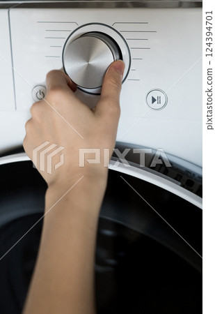 hand adjusts the washing program hand adjusts the washing program 124394701