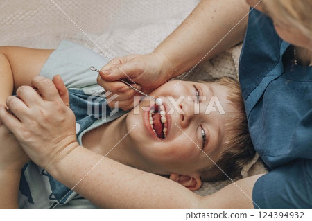 boy lying on soft white blanket during speech therapy session with female therapist in cozy room, concept of speech correction, childhood development, and healthcare, close up boy lying on soft white blanket during speech therapy session with female therapist in cozy room, concept of speech correction, childhood development, and healthcare, close up 124394932