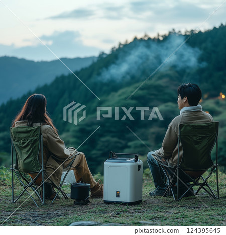 Relaxing evening in nature with friends by the camping chairs and mountains 124395645