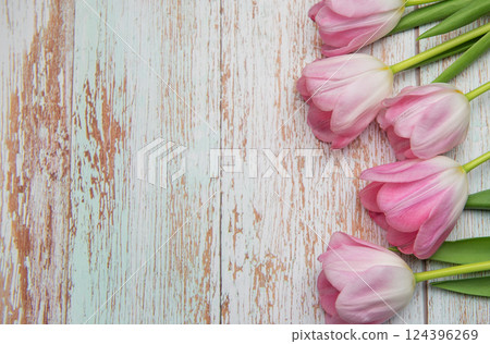 Pink tulips forming a border on rustic wooden background Pink tulips forming a border on rustic wooden background 124396269