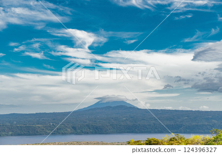 View of a beautiful volcano on a sunny day surrounded by vegetation. Landscape of a volcano with a blue sky surrounded by green vegetation, Nicaragua View of a beautiful volcano on a sunny day surrounded by vegetation. Landscape of a volcano with a blue sky surrounded by green vegetation, Nicaragua 124396327