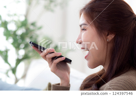 Young asian woman speaking on smart phone with chat bot ai, technology artificial intelligence. 124397546