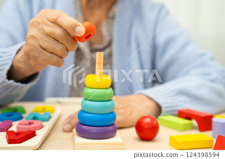 Alzheimer disease AD, Asian elderly woman patient suffering from dementia learn practical motor skills rehabilitation. Alzheimer disease AD, Asian elderly woman patient suffering from dementia learn practical motor skills rehabilitation. 124398594