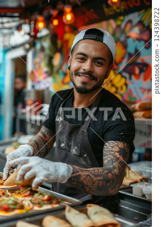A smiling street vendor prepares delicious tacos in a vibrant food stall, showcasing the joy of street cuisine. 124398722