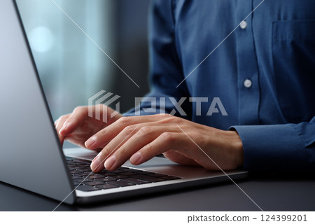 Close-up of hands typing on laptop keyboard. Businessman working at desk in office. Close-up of hands typing on laptop keyboard. Businessman working at desk in office. 124399201
