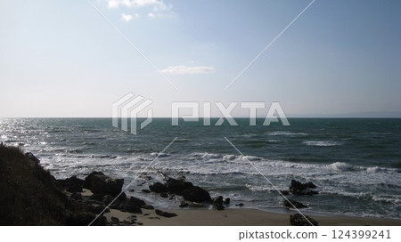 White waves crashing on the sandy beach and Sado Island floating in the Sea of Japan White waves crashing on the sandy beach and Sado Island floating in the Sea of Japan 124399241